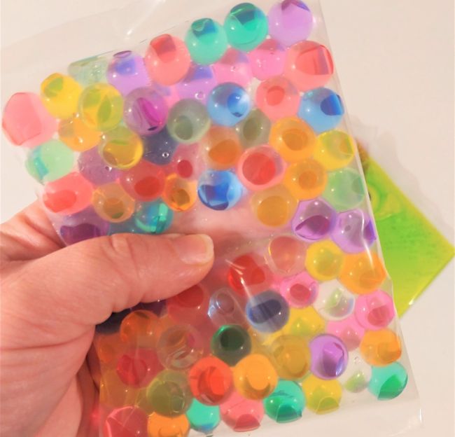 Sealed plastic bag filled with water beads in bright colors