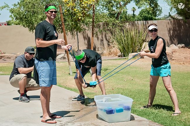 Players using a homemade catapult to launch soaking wet sponges