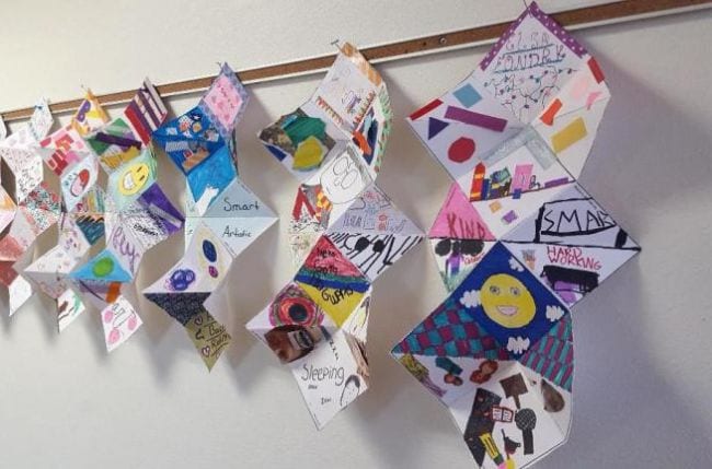 Folded paper squash books hung along the wall (Fifth Grade Art)