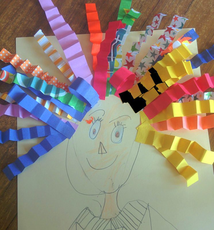 Pencil self-portrait of a child with hair made of folded construction paper strips