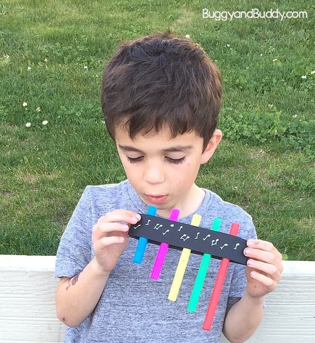 First grade science student playing a homemade pan flute