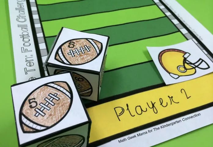 Paper dice printed with numbered footballs on a paper football field