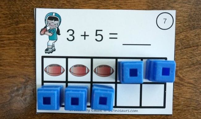 Ten frame card with equation 3+5, with three footballs and five blue blocks