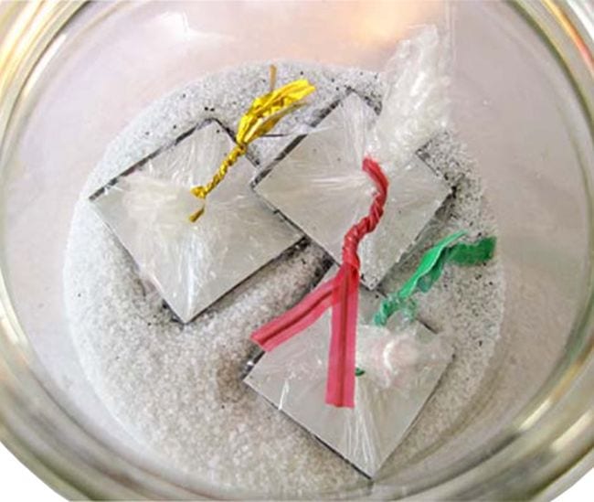 Jar of salt mixed with iron filings with plastic-wrapped magnetic tape bundles