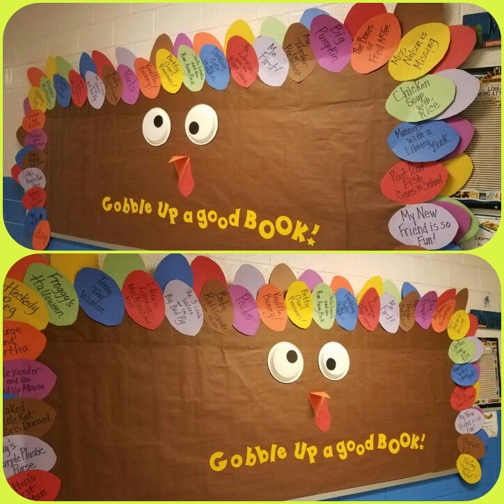 A bulletin board is designed to look like a turkey head. It has silly googly eyes and text reads "gobble up a good book." The names of books are written on the surrounding feathers.