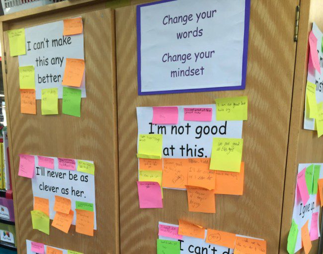 Posters with fixed mindset phrases like I'm not good at this, with sticky notes attached with growth mindset replacements