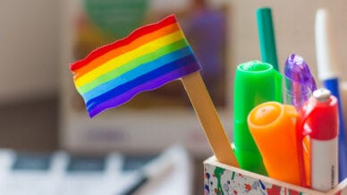Small rainbow flag on a pencil on a desk