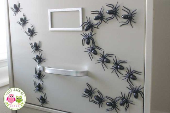 Plastic spider magnets on a filing cabinet spelling out I and S