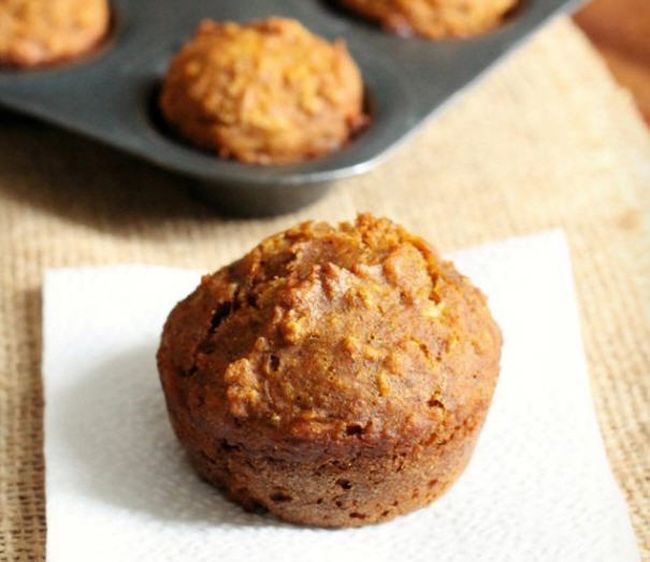 Healthy muffin on a white napkin with a tray of muffins in the background (Healthy Snacks for Kids)