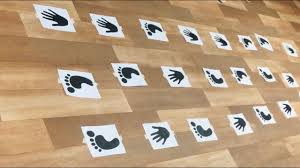 Print-outs of hands and feet on floor, as an example of pep rally activities and games