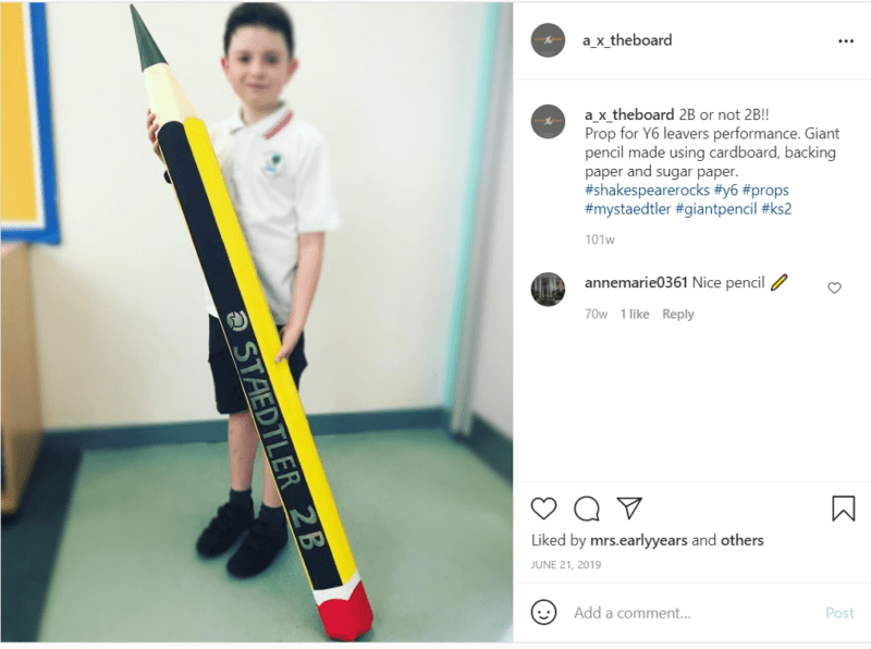 Student in white shirt and shorts holding giant pool noodle pencil