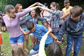A group of teens twisted together playing the human pretzel game