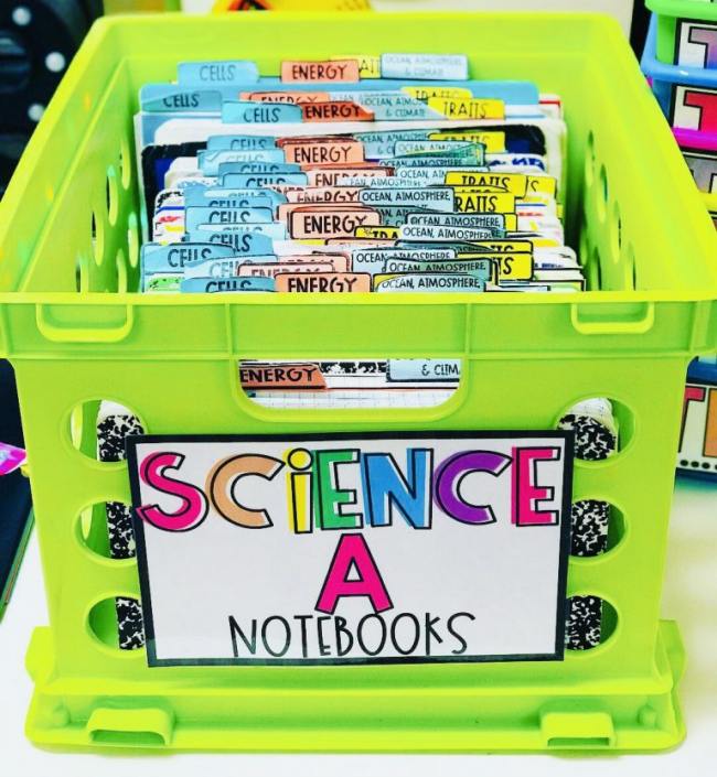 Science notebooks stored in a green plastic bin