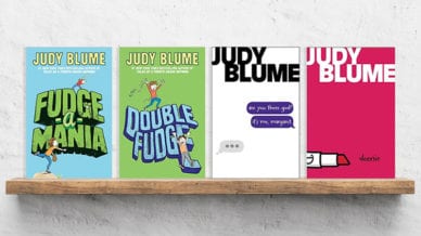 Four Judy Bloom books set on a wooden shelf in a classroom.