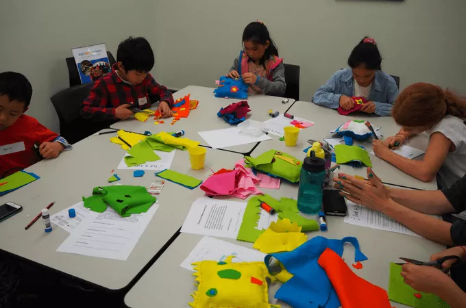 kids around a table sewing a stuffed animal