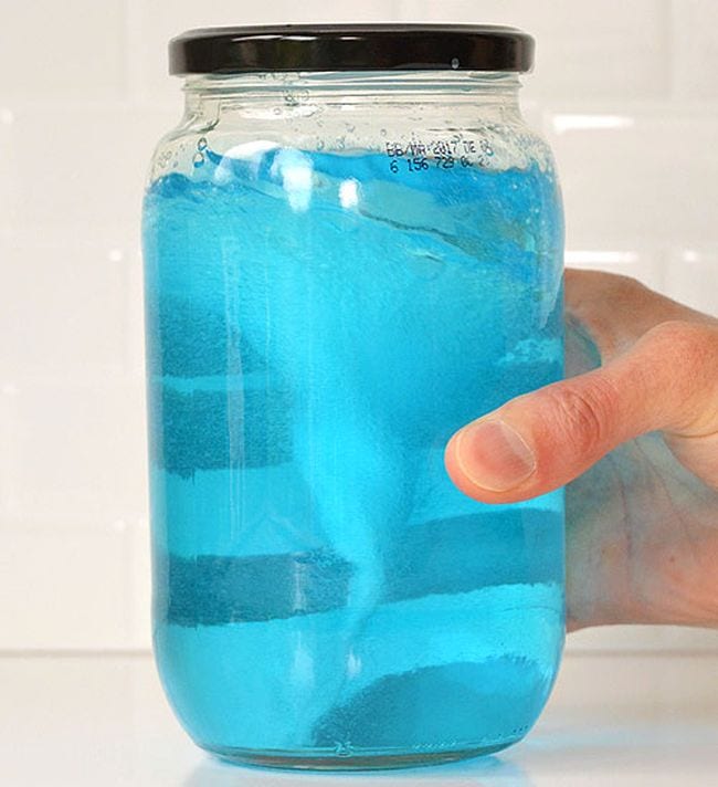 A jar filled with blue liquid and a foamy tornado inside (Kindergarten science)