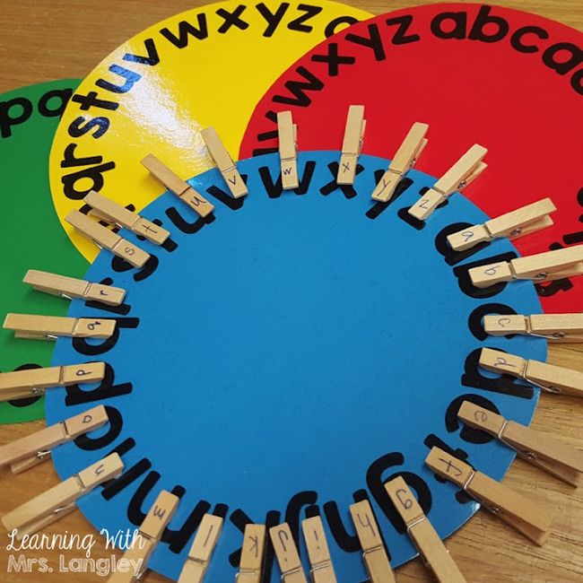 Colorful paper circles with the letters written around the edges, covered in clothespins