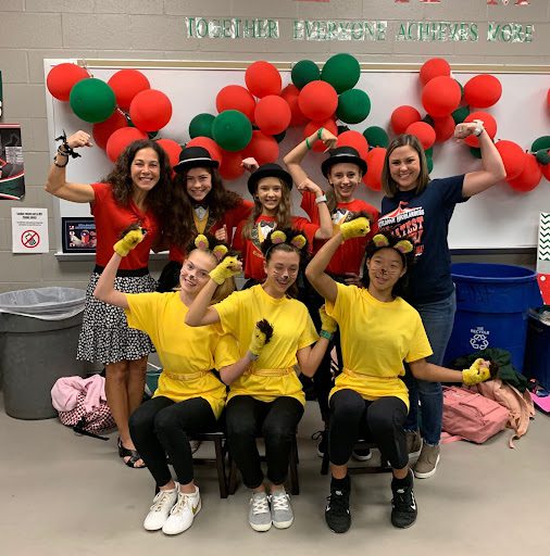 Kids dressed up in yellow shirts with balloons behind them