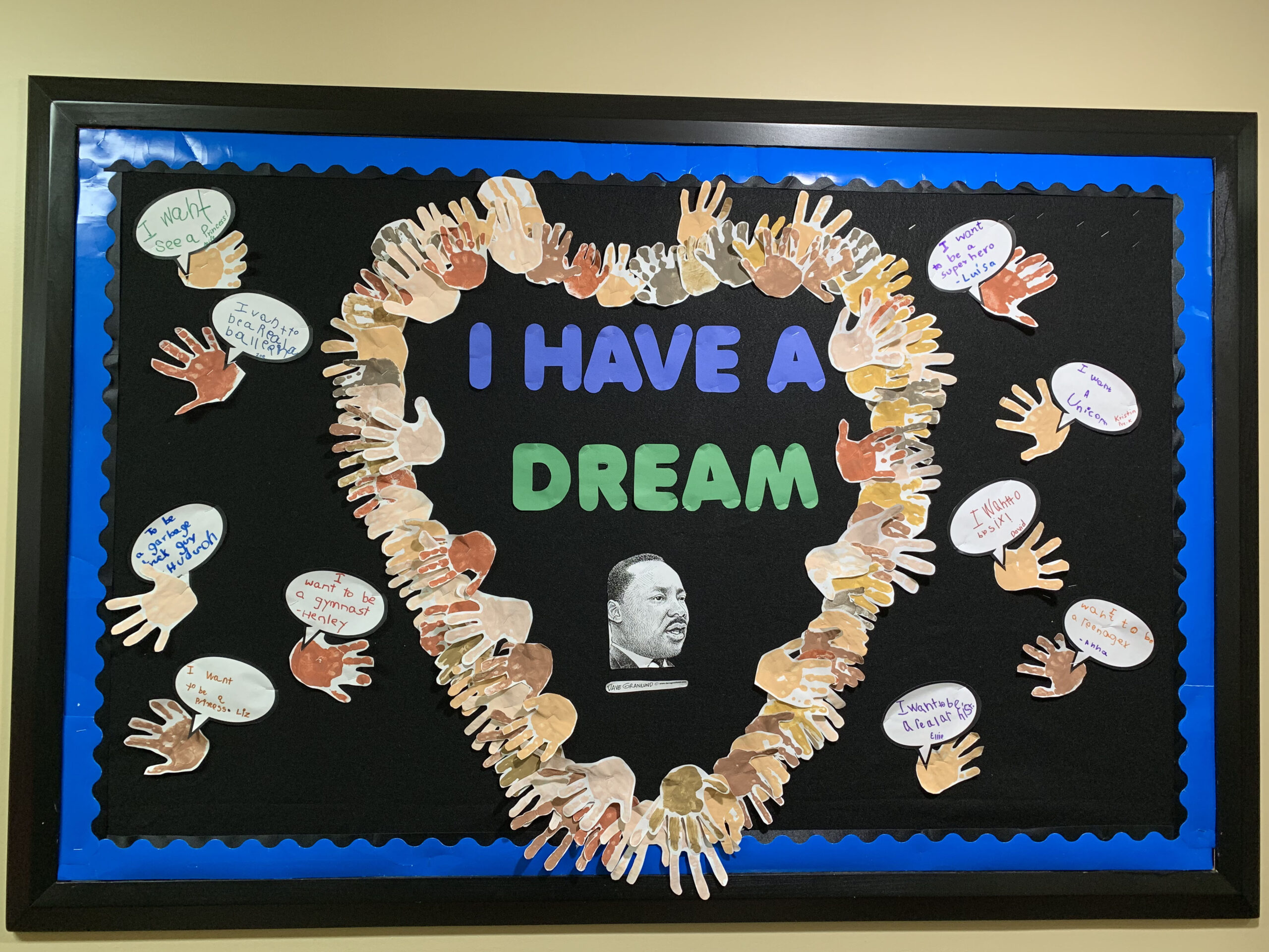 Text on a black background reads I had a dream.  there is a photo of Martin Luther King Jr.  and hand cutouts that form a heart around the photo (black history month bulletin board)