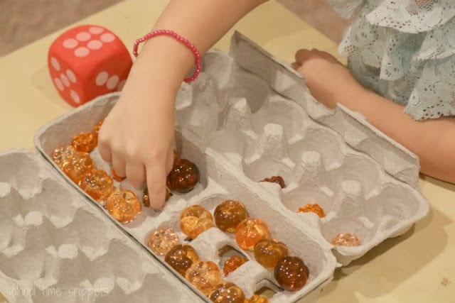 an egg carton with tiny glass pumpkins inside