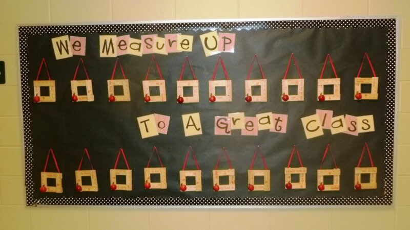 A black background has the words "we measure up to a great class." There are a number of squares made up of wooden rulers and each one has a small apple in the corner.