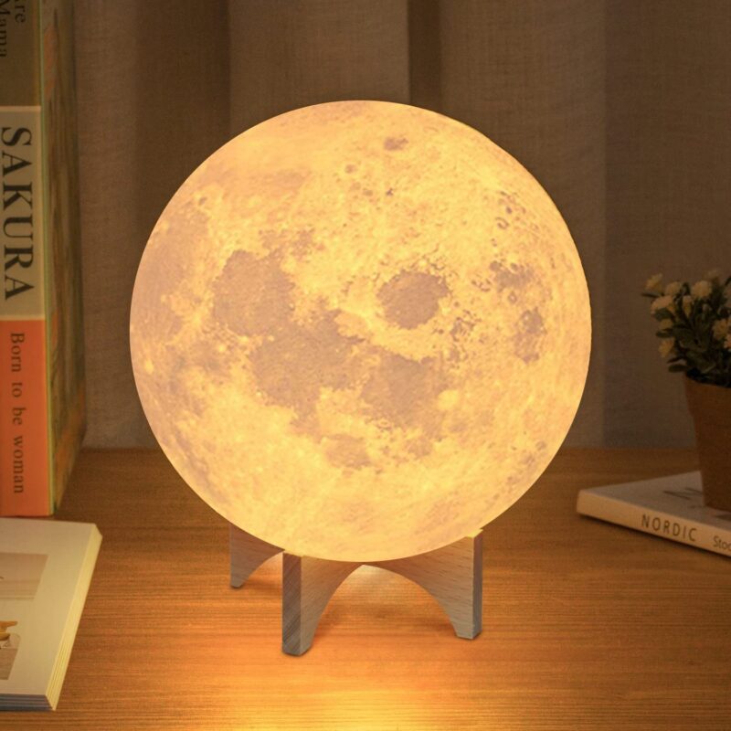 Moon lamp on a table with books and plant