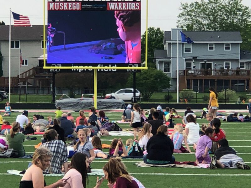 Students watching a movie on football field