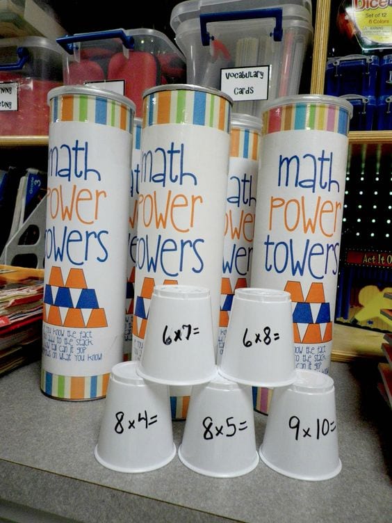 Plastic cups in tower form with multiplication problems written on them.