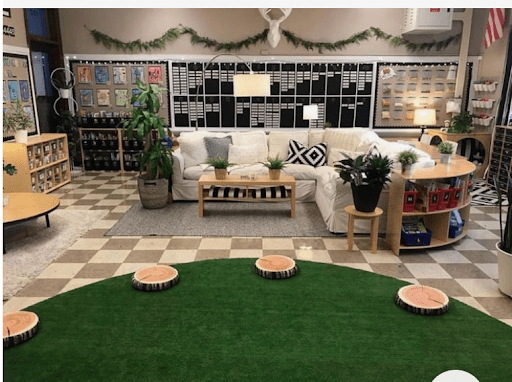 Classroom with green grass rug and stump stools as an example of a nature themed classroom