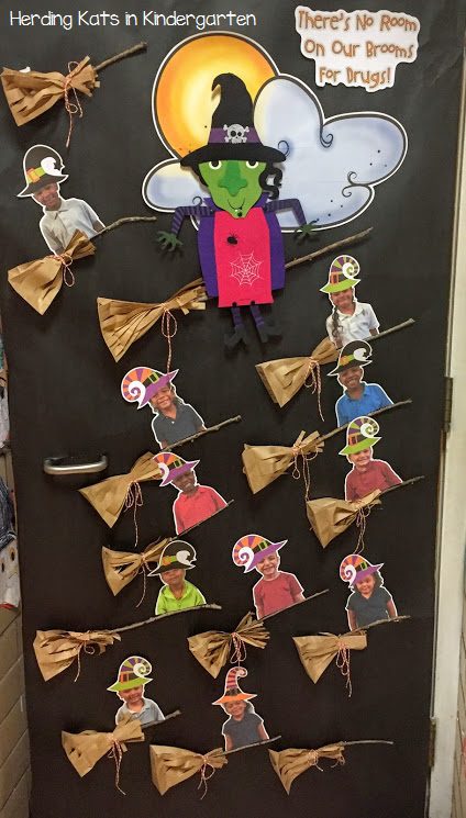 A door is decorated with a big witch and the text "there's no room on our brooms for drugs." There are several smaller witches riding on brooms and they have photos of the students' faces on them. 