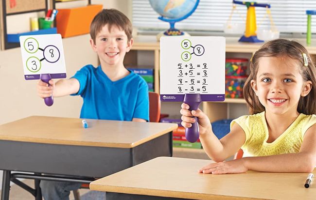 Two students holding up write-on, wipe-off number bond boards