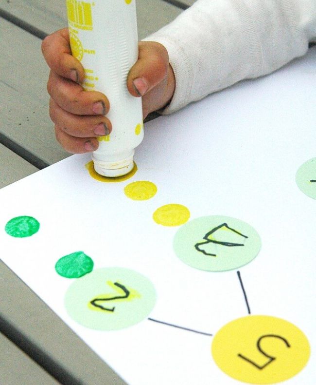 Child using dot marker to represent the parts of a number bond