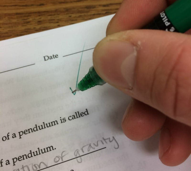 Teacher putting a check on an assignment