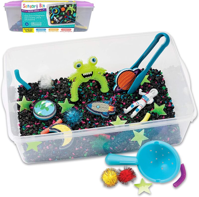 A clear bin has cute plastic outer space themed toys in it.