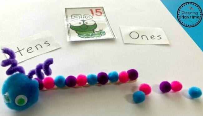 Cute bug made from one large pom pom and a series of smaller ones, with cards saying tens, ones, and 15 (Place Value Activities)