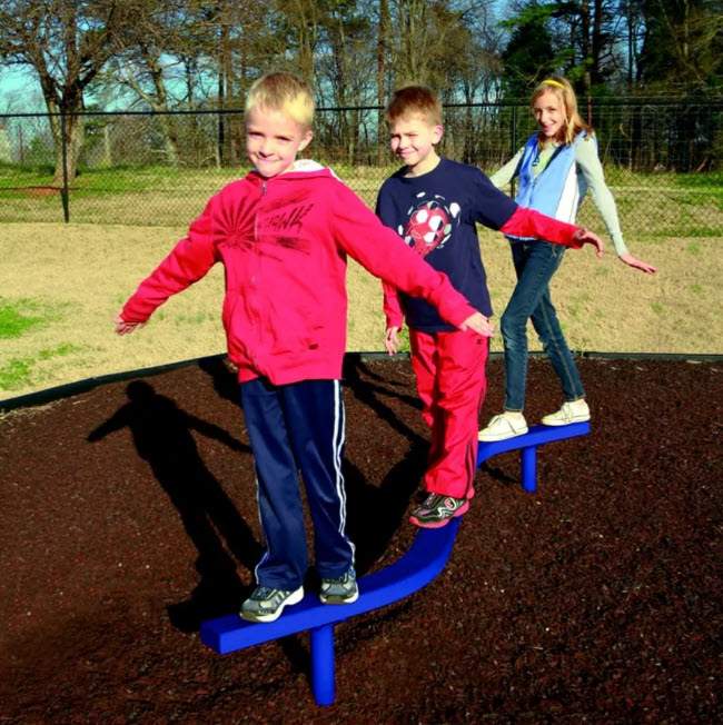 Children walking along a curved blue balance beam