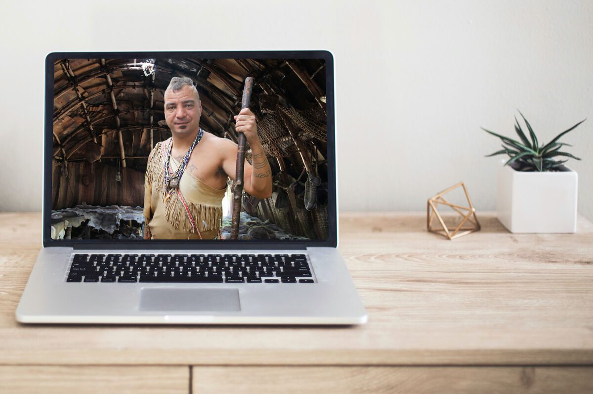 Desk with laptop featuring a Wampanoag Native American.