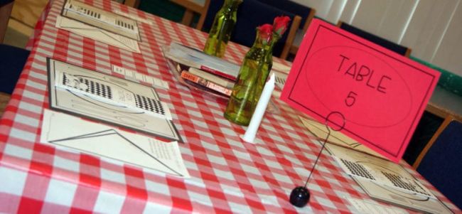 Table set to look like a restaurant, with poetry books at each place setting