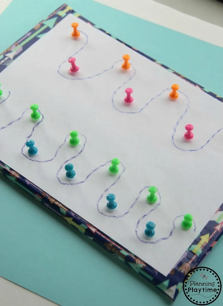 A piece of paper is shown with push pins in it and a cryon has been used to trace around the push pins (fine motor activities)