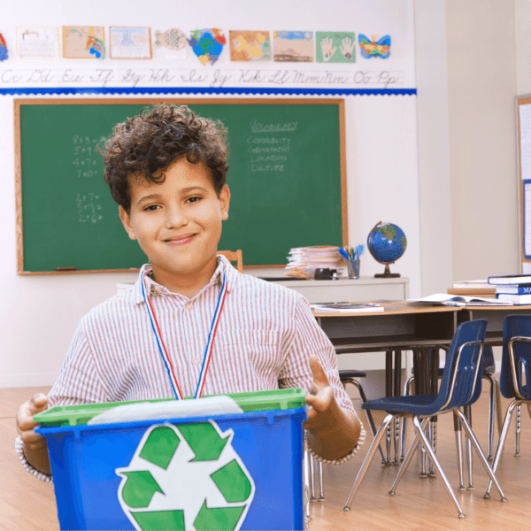 young boy collecting the classroom recycling