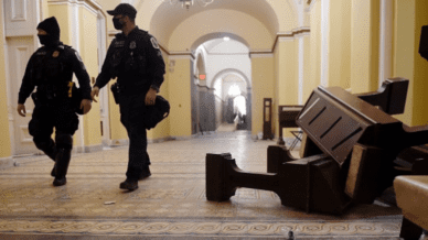 Capitol building attack showing security guards walking through hall