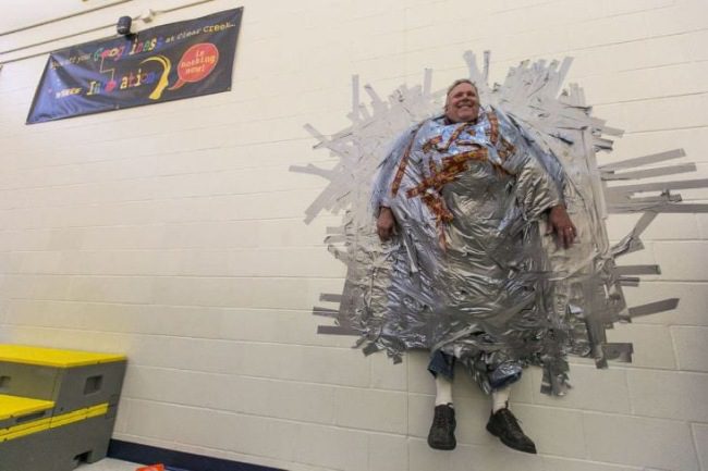 Principal duct-taped to cafeteria wall by his students as a spirit event