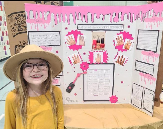 Girl standing with her science fair project board about nail polish