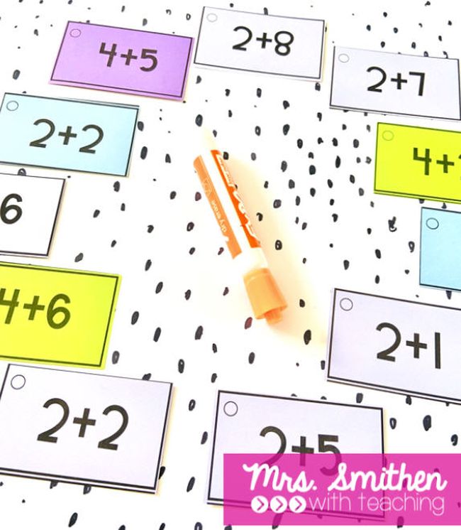 Math flashcards laid out in a circle, with a dry erase marker in the middle