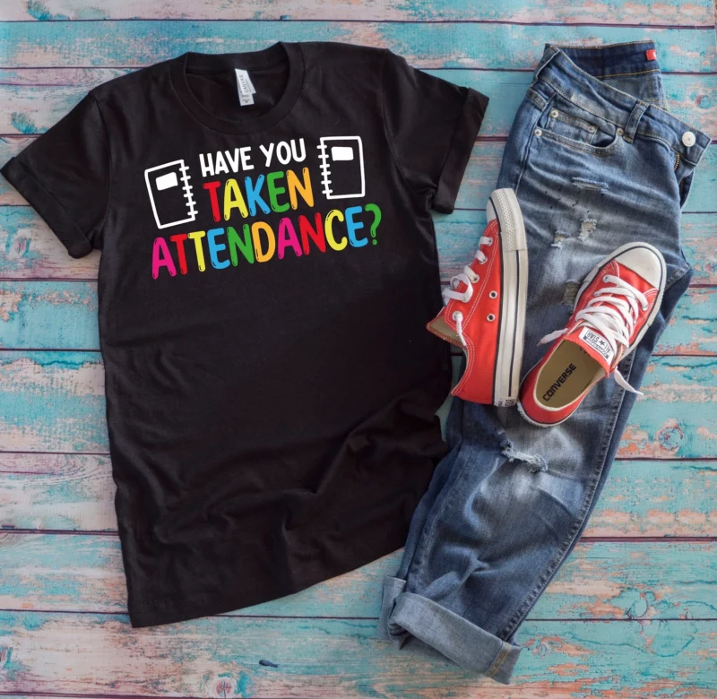 Jeans, red sneakers, and a black shirt that says, "Have You Taken Attendance?"