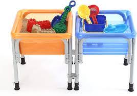A table is divided in two. An orange table is filled with sand and the blue side is filled with water (sensory toys)