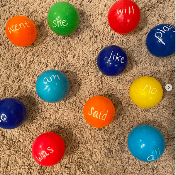 Small multicolored plastic ball pit balls with sight words written in chalk marker