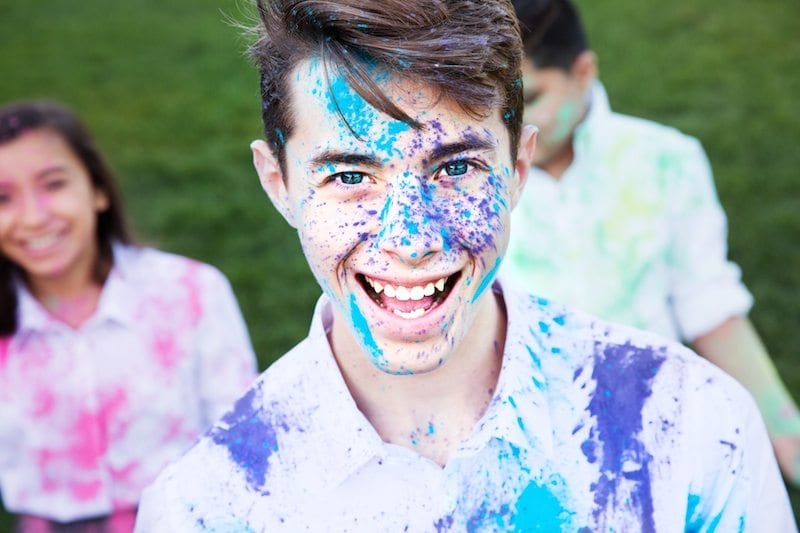 young boy with colorful paint on face and clothes - motivating students