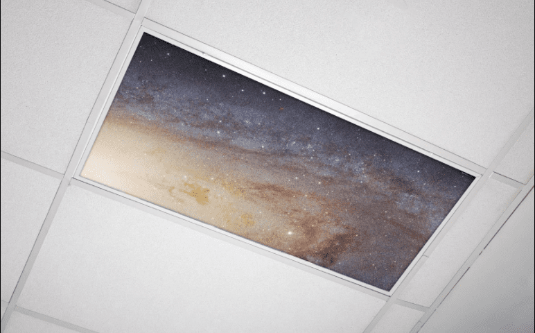 Space themed fluorescent light cover in classroom ceiling