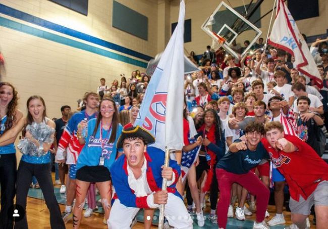 Students at a school pep rally wearing school colors and cheering